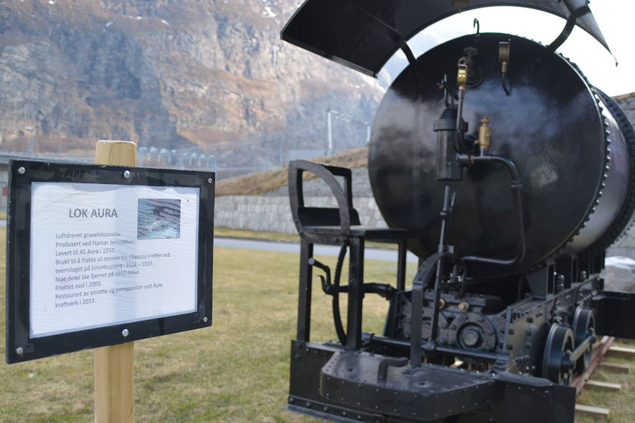 A train engine from the construction period has been restored and placed outside the power plant